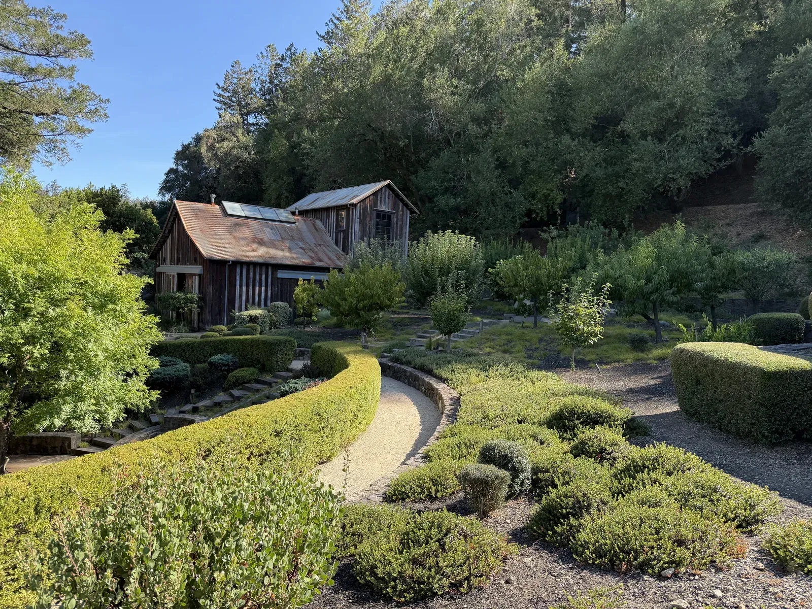 Wide view of the DANA Estates gardens with the reclaimed barn and outbuildings behind