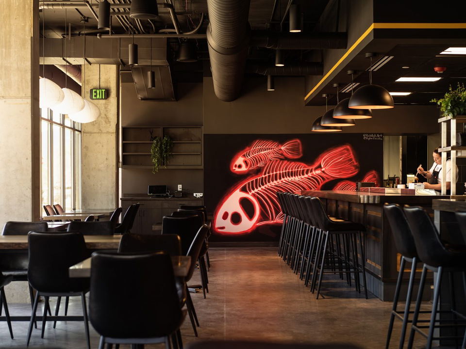 Odd Rabbit (Boulder) interior with a glowing red fish skeleton mural and modern industrial design.