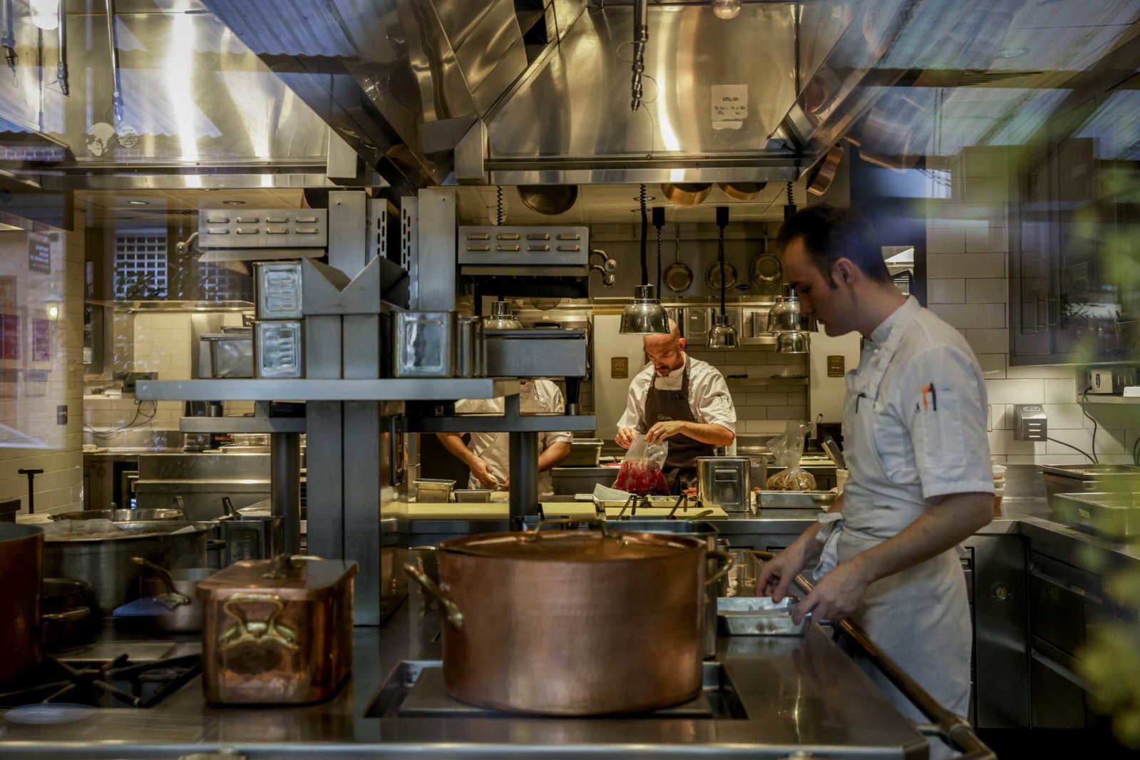 Quince SFRestaurant Design and Setting features gleaming copper pots amidst the busy, stainless steel kitchen.