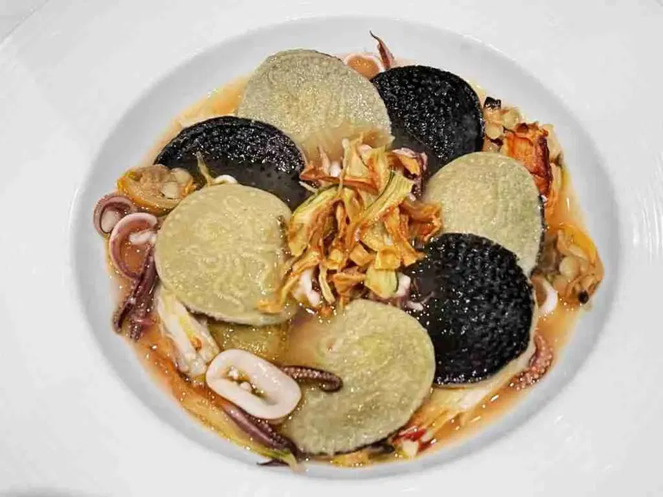 La Toque's truffle tasting menu features black truffle discs and green dumplings with squid and crispy garnish.