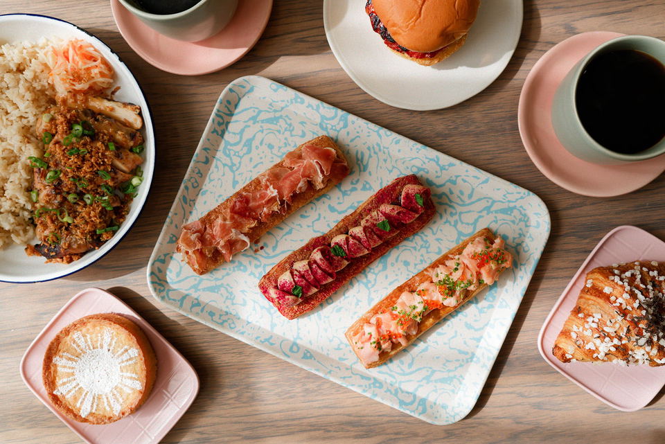 A vibrant spread of Filipino-inspired dishes and pastries, including a hearty rice and chicken plate, savory toasts, a burger, and sweet treats,...