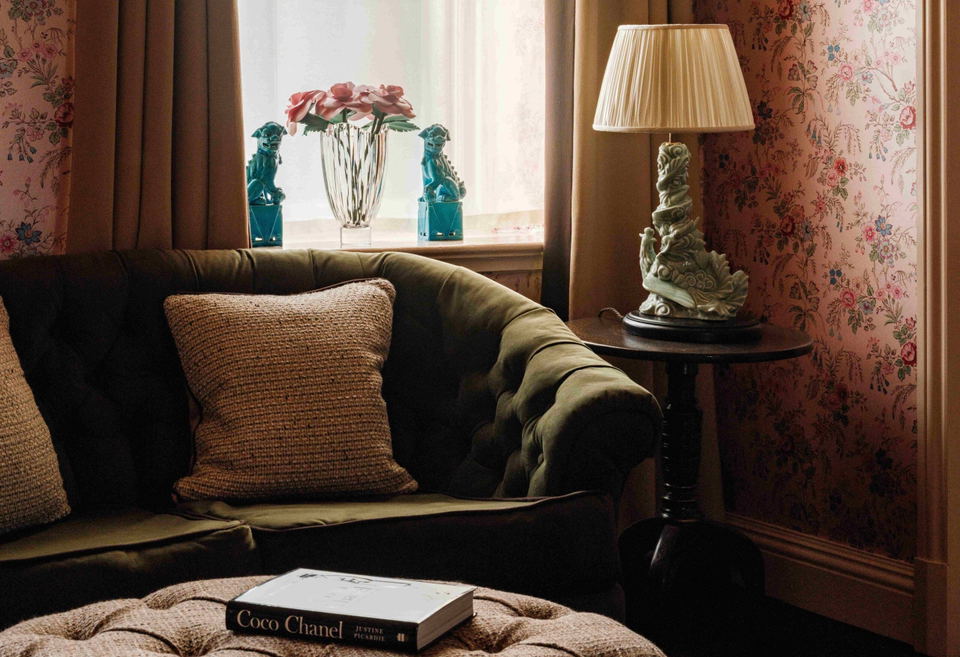 The fife arms coco chanel room, with its iconic pink floral wallpaper and cozy furnishings.
