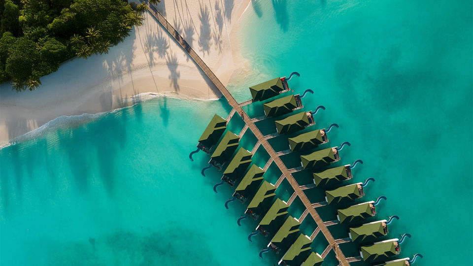 Kudafunafaru Island: Overwater bungalows extend into turquoise waters from a white-sand beach.