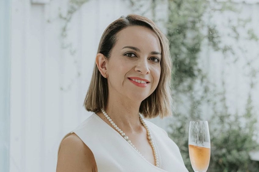 Verónica Santiago enjoys a glass of sparkling wine at an outdoor event.