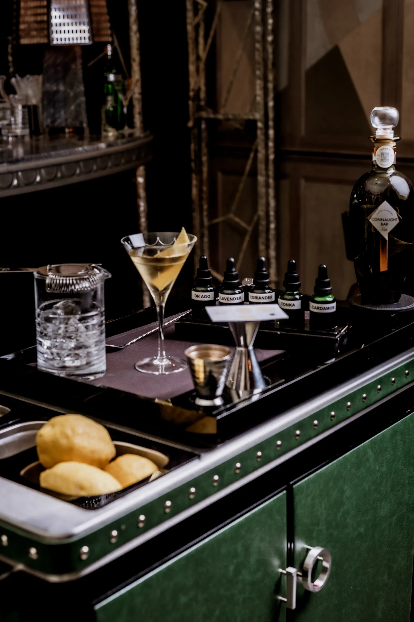 The Martini Trolley and Bar Design features a rich, dark green finish with polished silver studs.