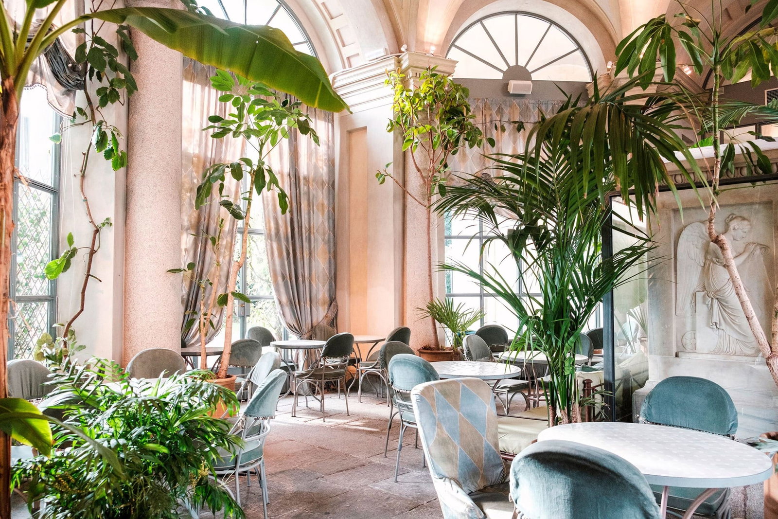 Ambiance and Service Style, featuring an abundance of lush green plants throughout the bright, open space.