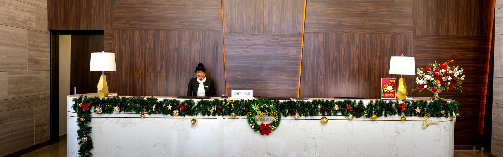 Reservations and Entry Process features a desk adorned with festive green garland and golden ornaments.
