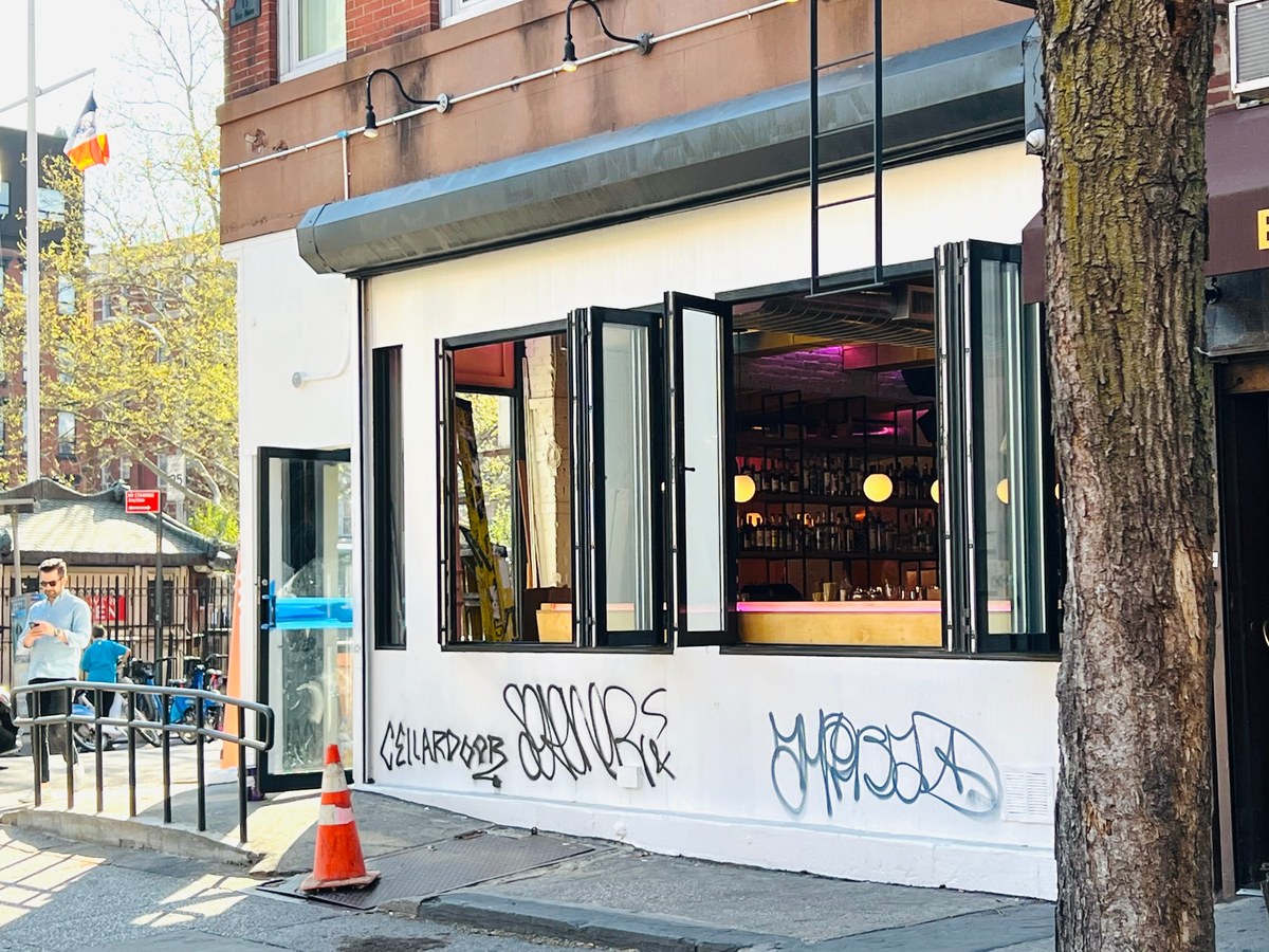 Superbueno's modern exterior with graffiti and inviting bar interior.