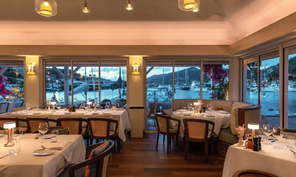 ISBA by Bagatelle (Palm West Beach) offers a serene waterfront view with yachts visible through expansive windows.