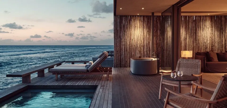 Taiga (Bluewaters) features a distinctive wall crafted from vertical wooden slats, illuminated by soft spotlights.