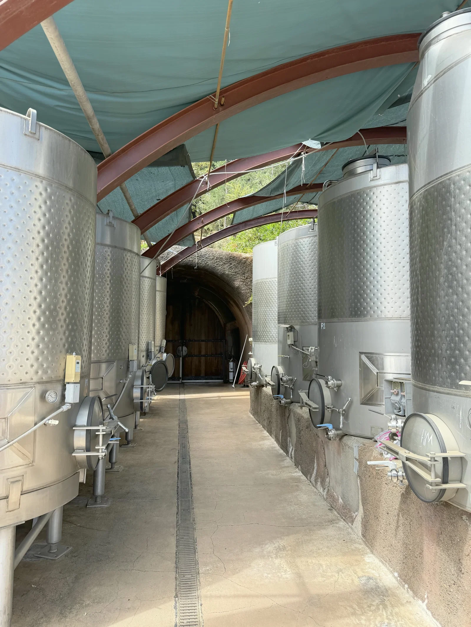 Rows of stainless-steel fermentation tanks leading toward the Dunn Vineyards cave