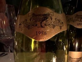 A 1986 Domaine Jean-François Coche-Dury Corton-Charlemagne Grand Cru bottle, a testament to fine white wine trading.