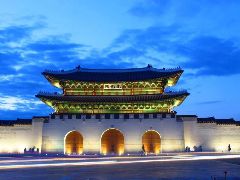 Gwanghwamun Gate, Seoul, illuminated at night, highlighting the Four Seasons Tokyo to Seoul Package's unique appeal.