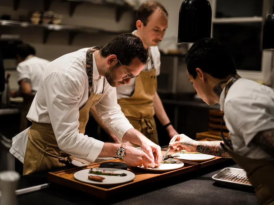 Harbor House kitchen team plating dishes together during service