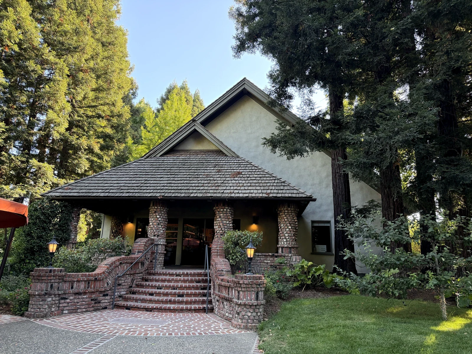 German Tudor Revival entrance with brick steps, stucco and redwoods at Harvest Inn