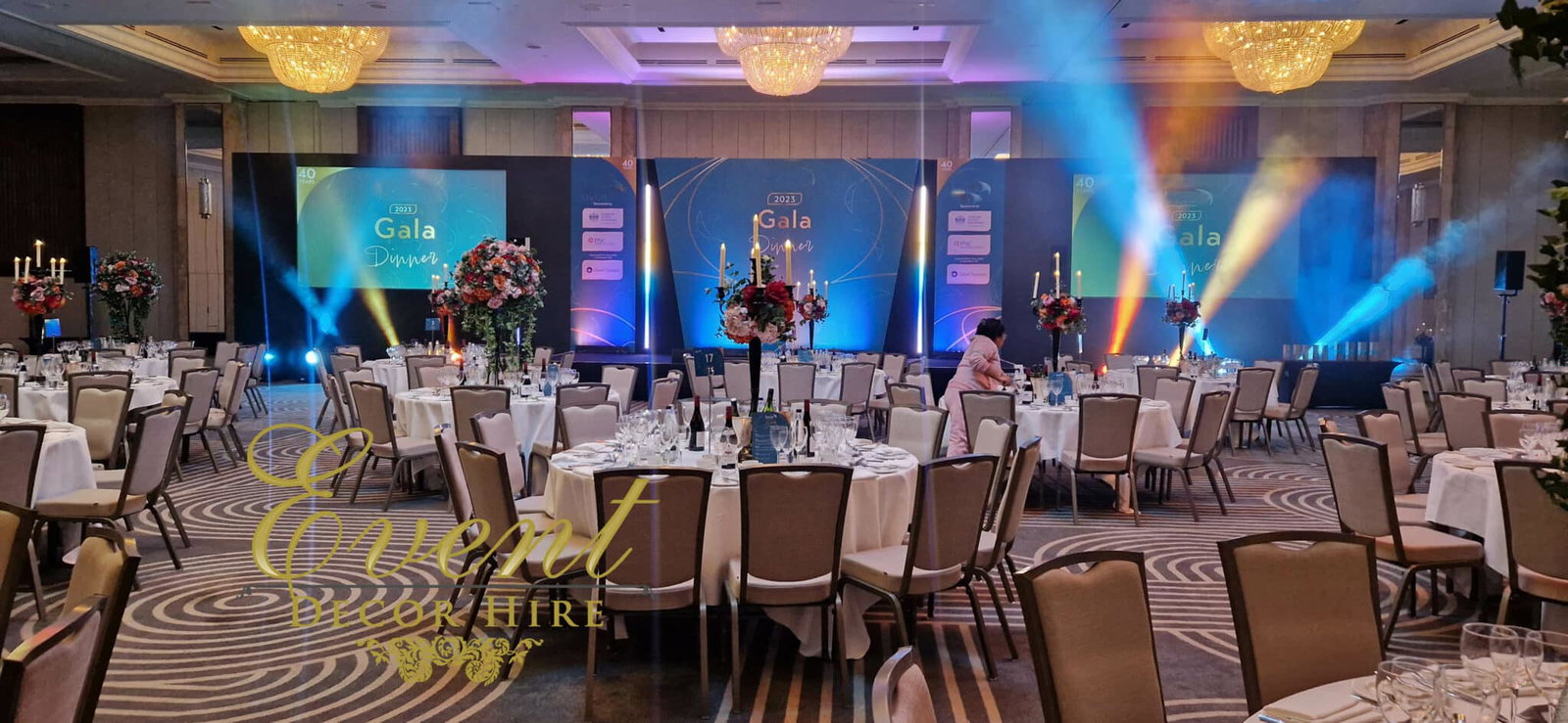 The Gala Dinner features a grand ballroom filled with numerous elegantly set round tables.