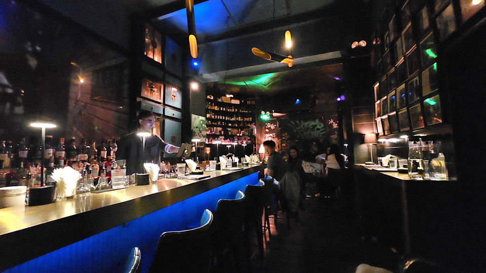 Hope & Sesame's new retail shop, a modern cocktail bar with a blue-lit counter and bar seating.