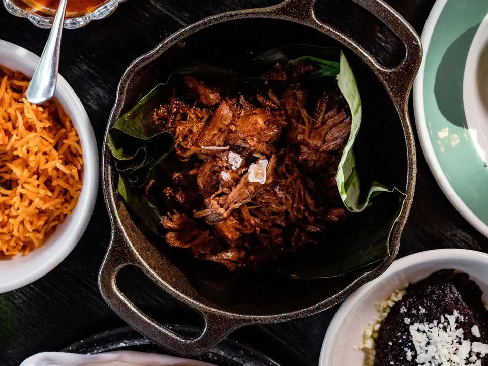 Cochinita & Co.'s cochinita pibil, with sides of rice, beans, tortillas, and salsa roja.