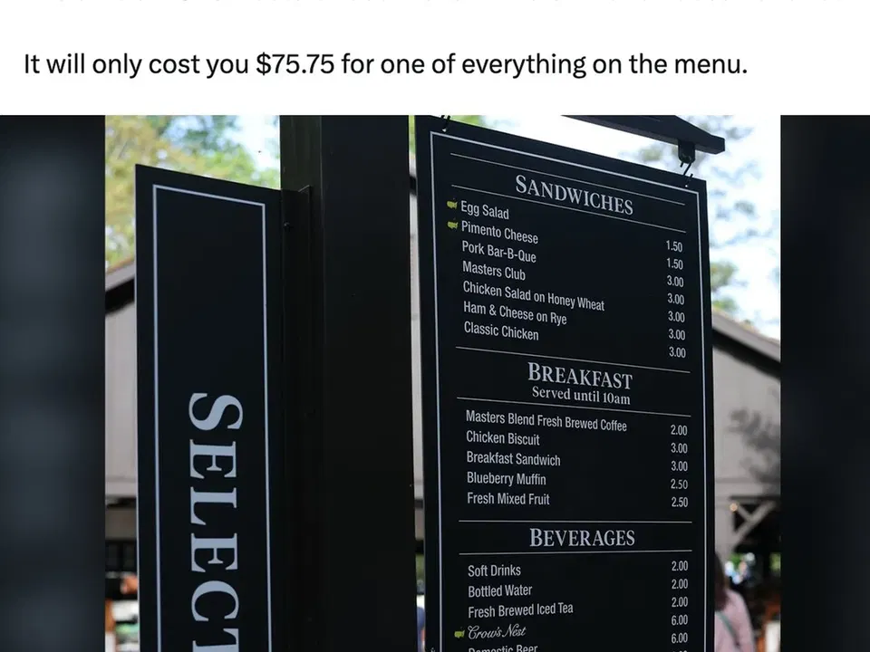 Black menu board showing sandwich, breakfast, and beverage offerings at what appears to be a Masters event food venue, with individual item prices listed.