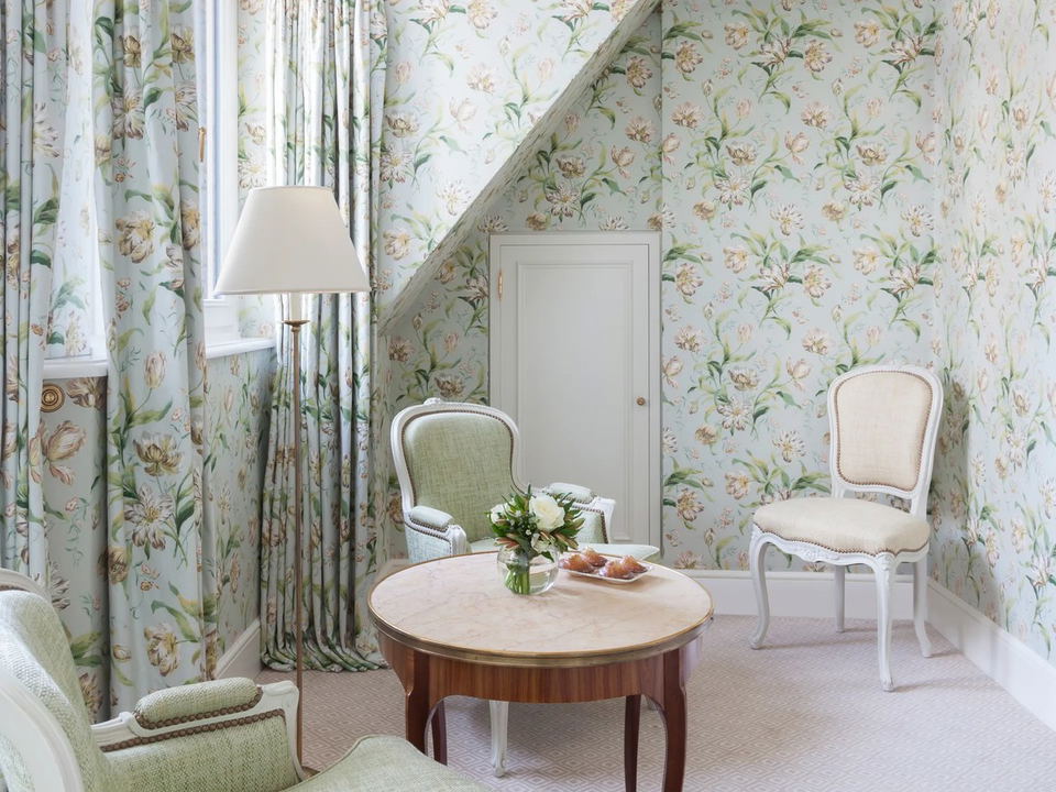 Le Bristol Paris: An elegantly decorated sitting room with floral wallpaper and Louis XVI-style chairs.