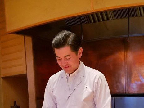 A chef plating a dish in the kitchen