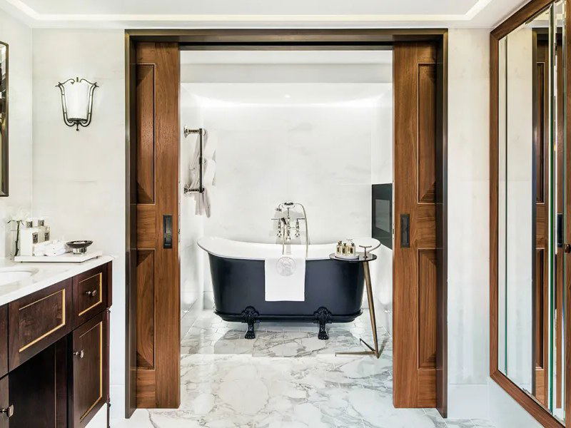 The Arts Club London offers luxurious bathrooms with elegant dark wood and marble finishes.