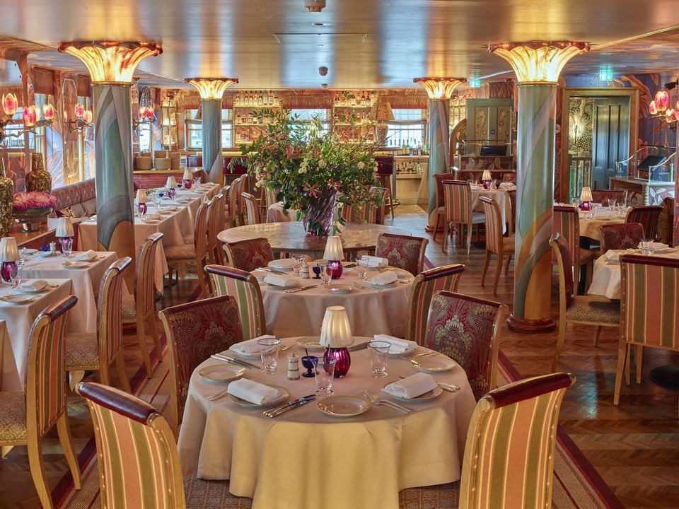 5 Hertford Street: An opulent dining room with floral columns, striped chairs, and warm amber lighting.