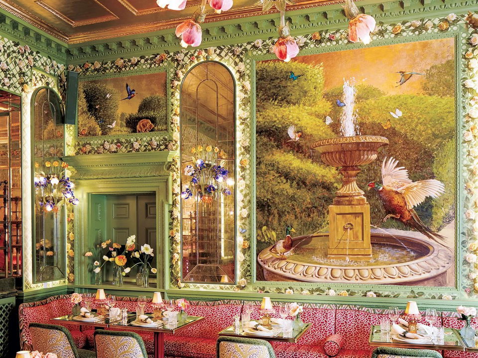 Annabel's: A maximalist dining room with a floral chandelier, garden mural, and vibrant banquette seating.