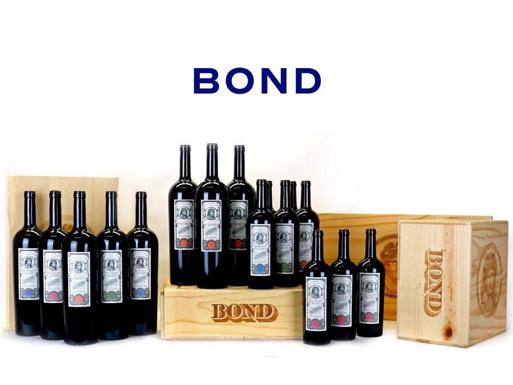Multiple bottles of Bond wine arranged with wooden cases branded with the Bond logo.