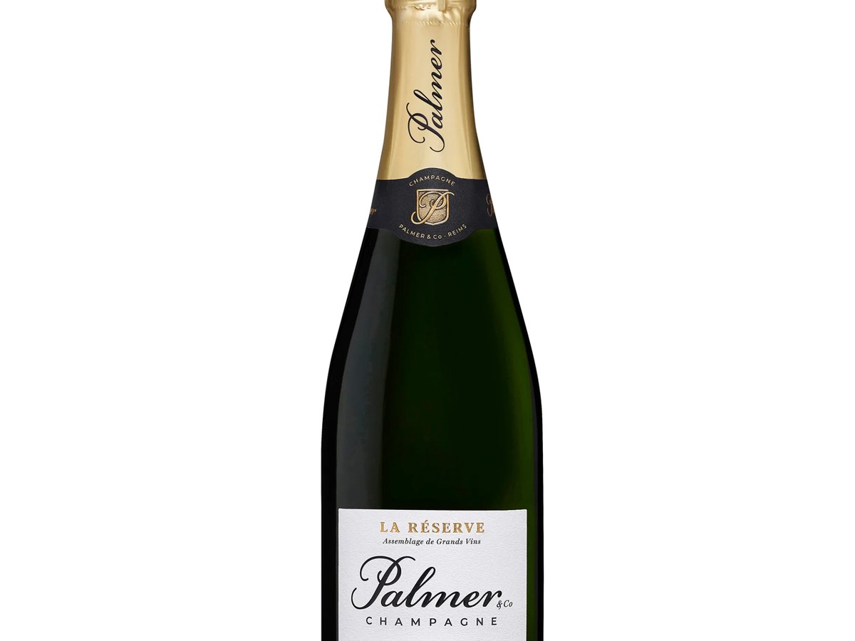 A bottle of Palmer & Co. Champagne La Réserve, featuring a gold foil top and a white label with black text.