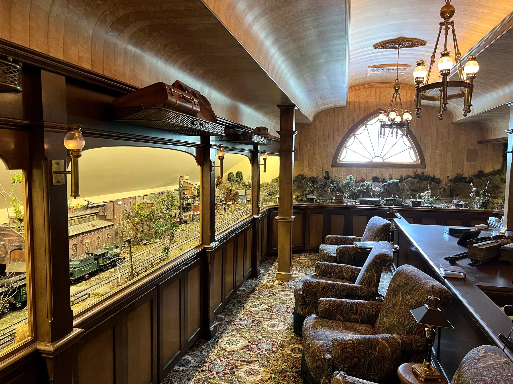 Elaborate hidden model railroad room with glass displays and upholstered chairs above the Meadowbrook carriage house