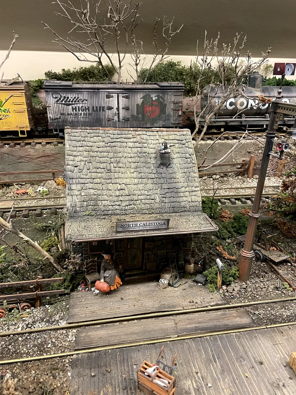 Detailed Meadowbrook model railroad scene with station, freight cars and miniature landscaping
