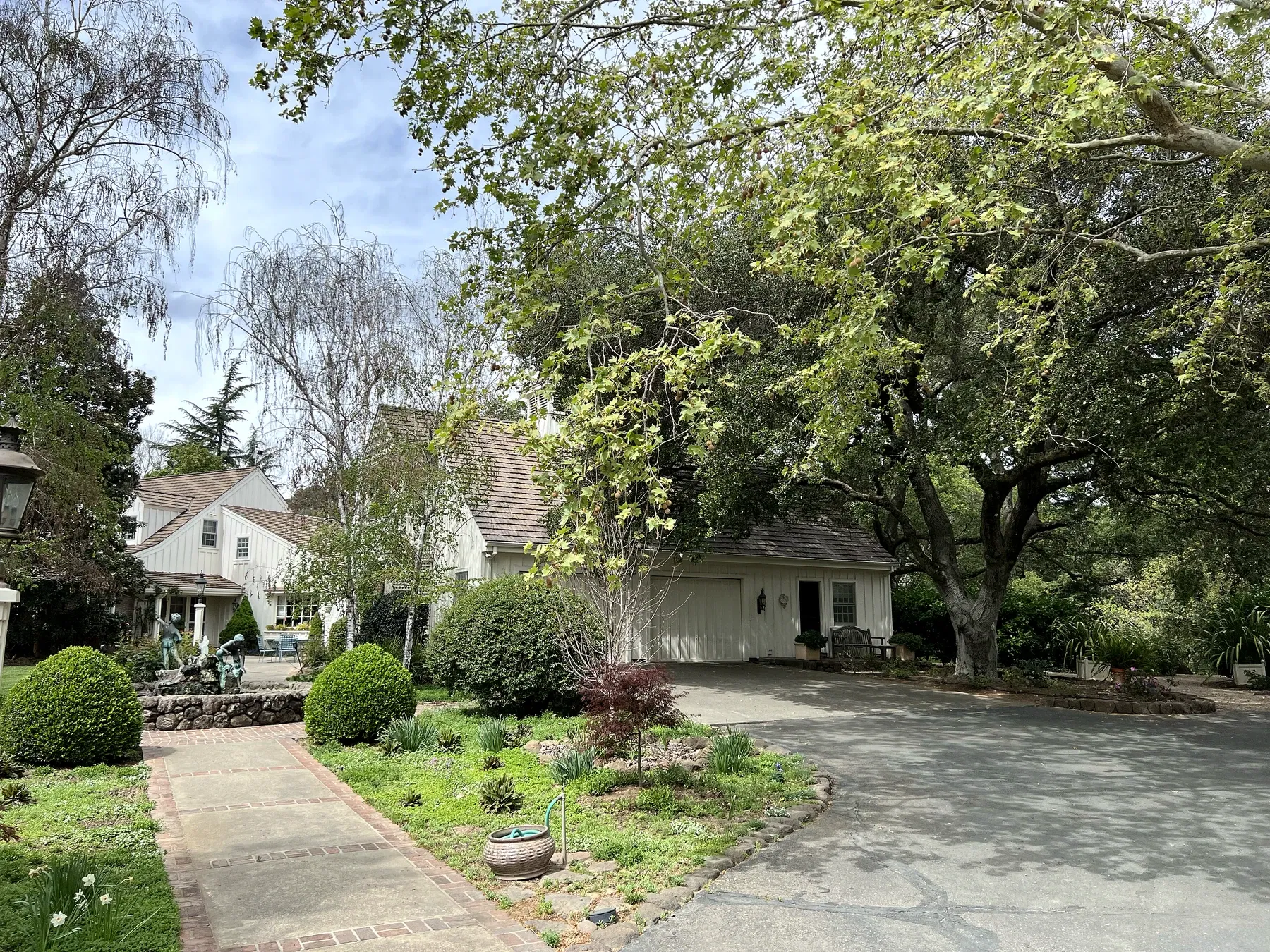 Historic pale residence and curving drive beneath mature trees at Kanpai's Meadowbrook Farm