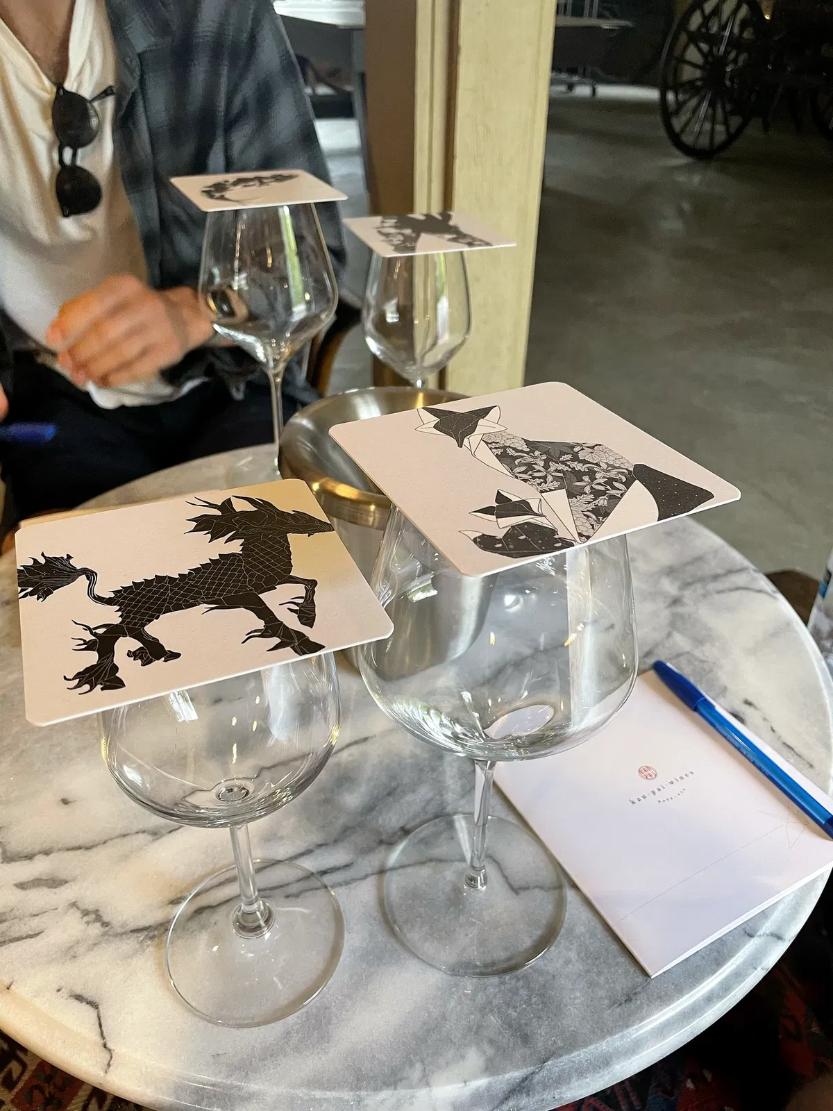 Wine glasses and black-and-white mythical animal cards set for a private Kanpai Wines tasting