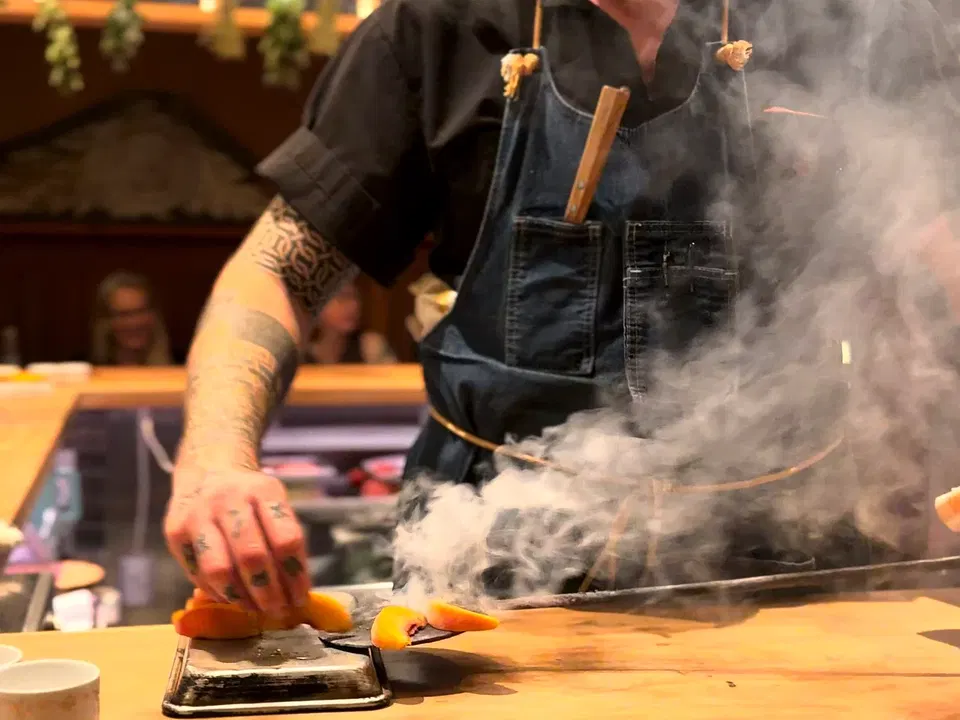 Joseph Magidow cooking through a cloud of smoke at La Cigale’s live-fire counter