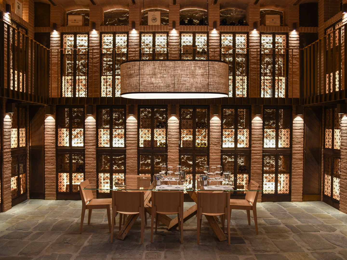 The Verticals Tasting showcases a long glass-top table set with many wine glasses.