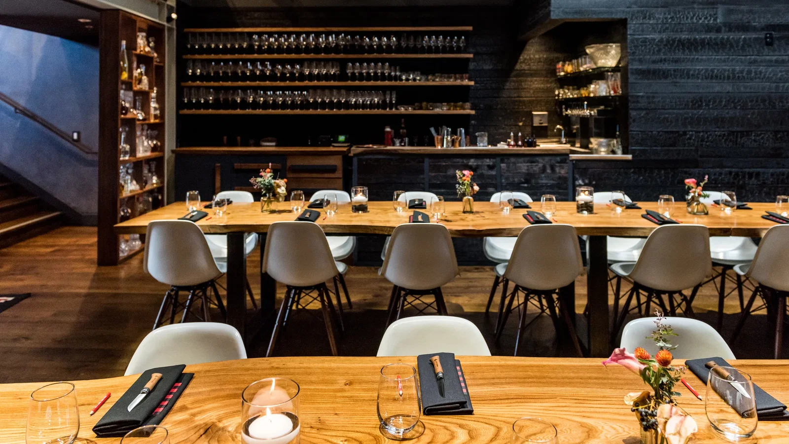 Planning Your Visit to Lazy Bear SF, featuring a long communal wooden table set for dinner.