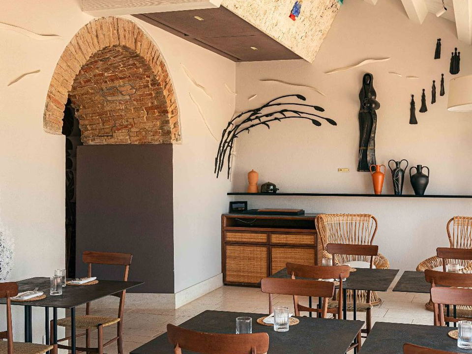 Le Dune Piscinas Ecoresort blends adaptive-reuse architecture with rustic walls and eclectic decor in its dining room.