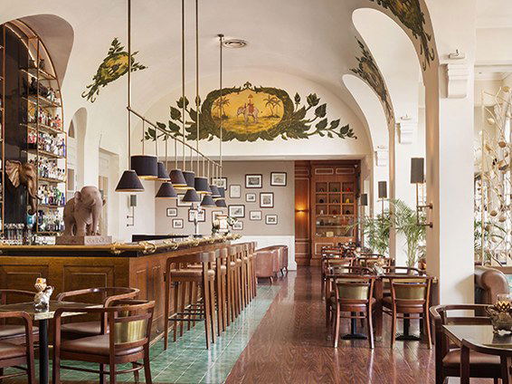 The Elephant Bar at Raffles Hotel Le Royal, Phnom Penh, a colonial icon with tropical murals and rich wood.