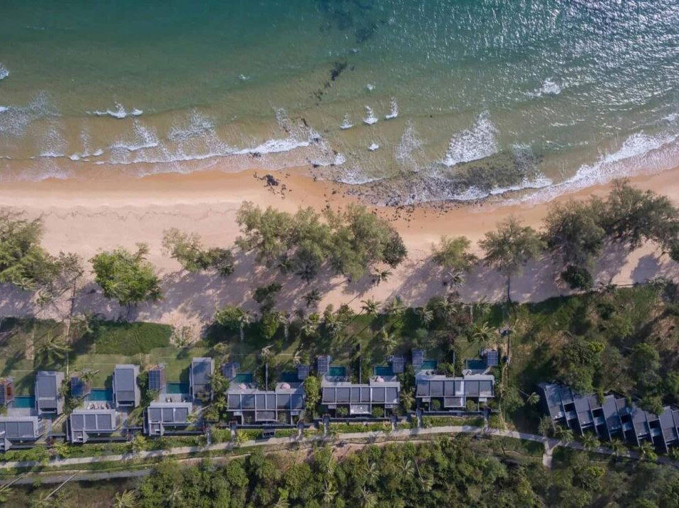 Aerial view of Koh Russey Villas & Resort, showing beachfront villas with private pools, a sandy beach, and the turquoise Gulf of Thailand.