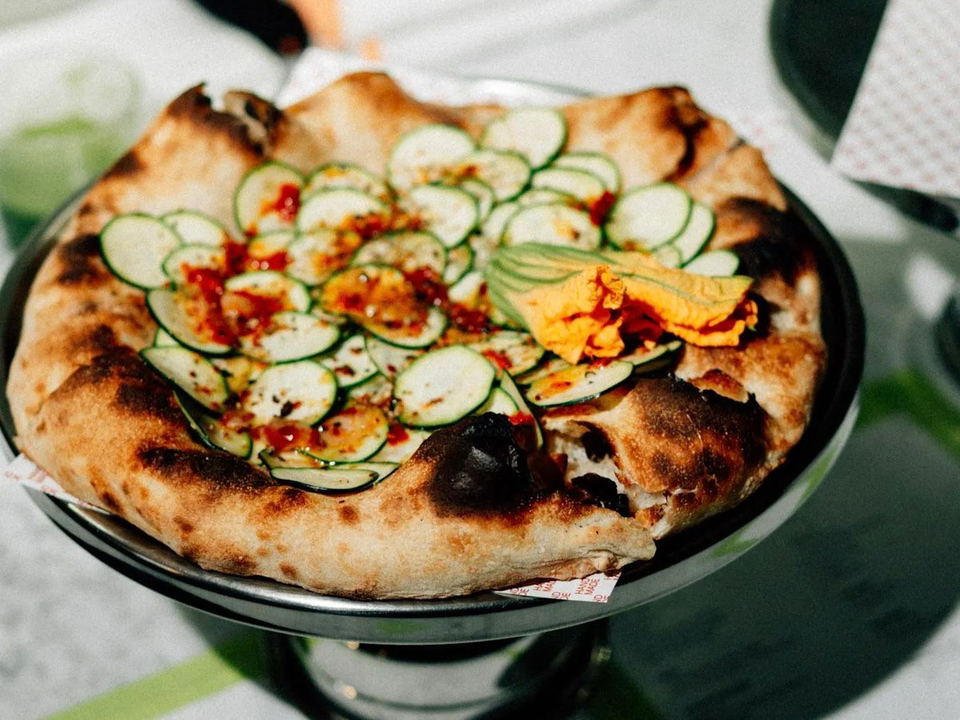 Lynx's pizza, with charred crust, zucchini, chile flakes, and a vibrant squash blossom, is worth the pilgrimage.