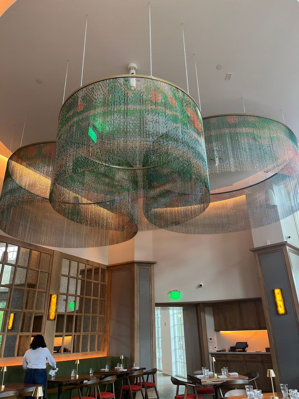 Café Monet (McLean) showcases large, intricate chain-link chandeliers with vibrant green and orange hues.