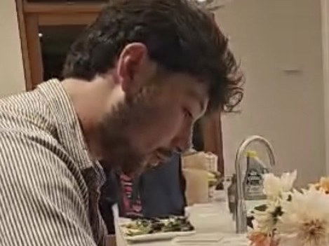 A person plating desserts in a modern residential-style kitchen with white cabinetry and marble backsplash; the Michelin Guide source page explicitly