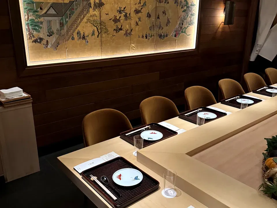 Muku’s warm wood counter and illuminated wall panel before service in Tribeca