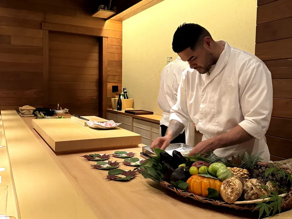Manabu Asanuma presenting seasonal Japanese vegetables and ingredients across Muku’s counter