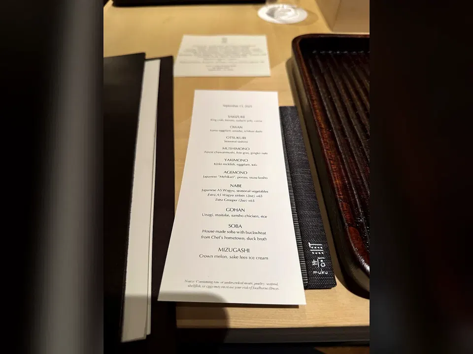 Printed Muku tasting menu dated September 13, 2025 on the counter