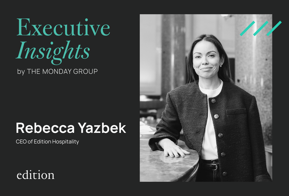 Professional portrait of a woman in a dark blazer seated at a table in an office or hospitality setting; the source page explicitly attests this is Re