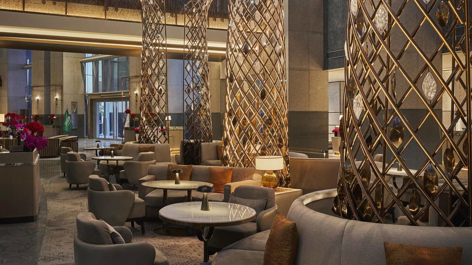 The Obaya Lounge at Four Seasons Riyadh, featuring comfortable seating arrangements, decorative golden pillars, and elegant lighting.