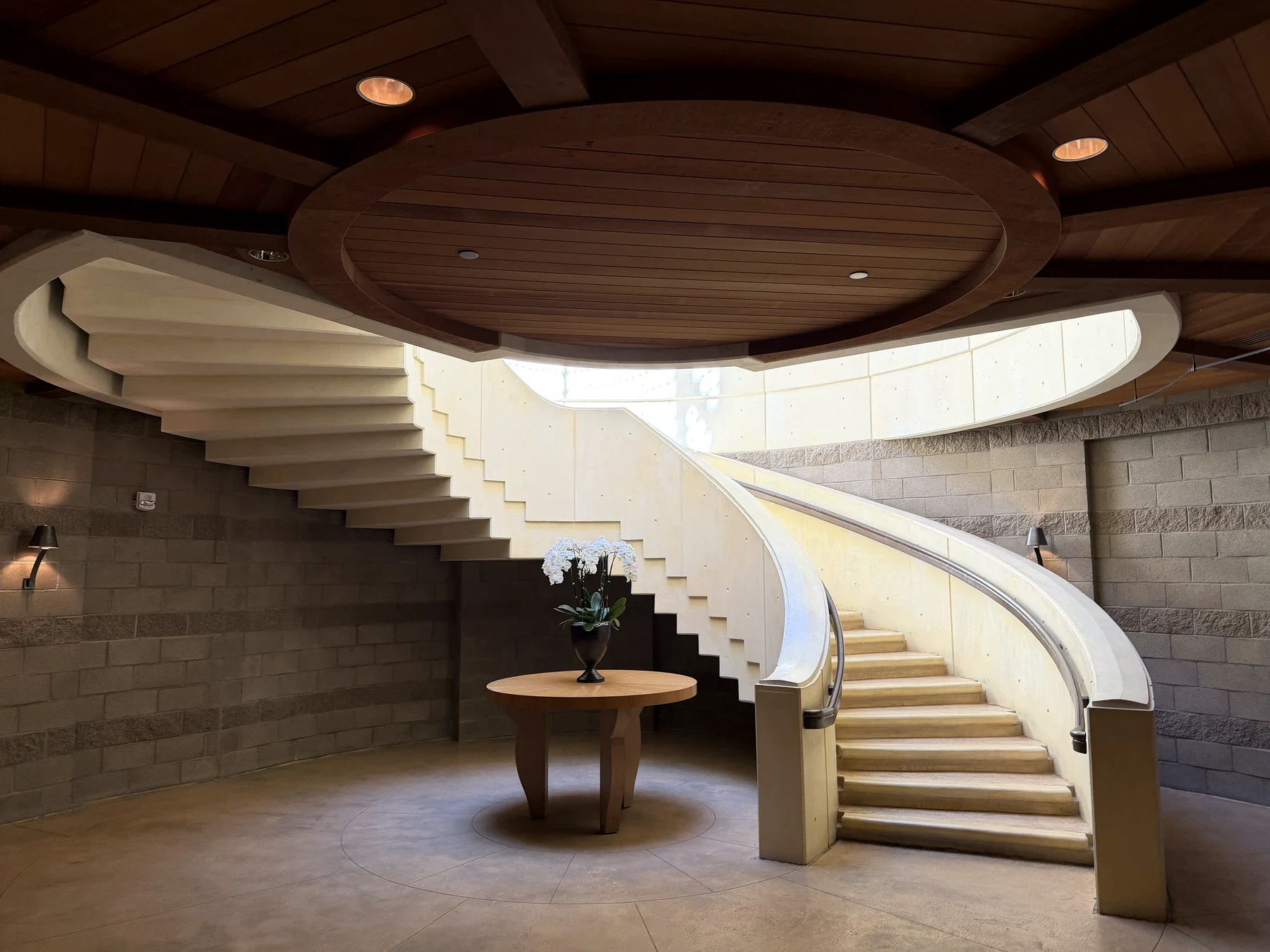 Curved white staircase beneath a circular wood ceiling inside Opus One Winery