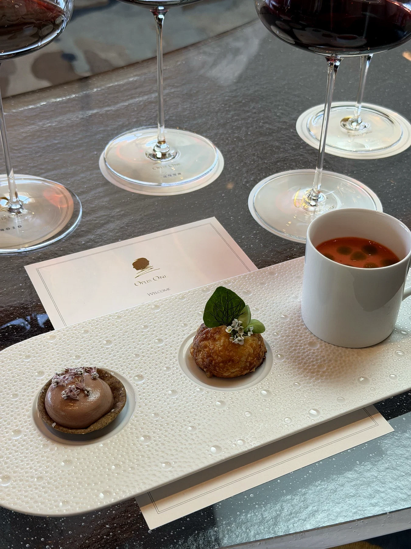 Sean Koenig's duck liver Mont Blanc, Gruyère gougère and strawberry gazpacho beside Opus One glasses